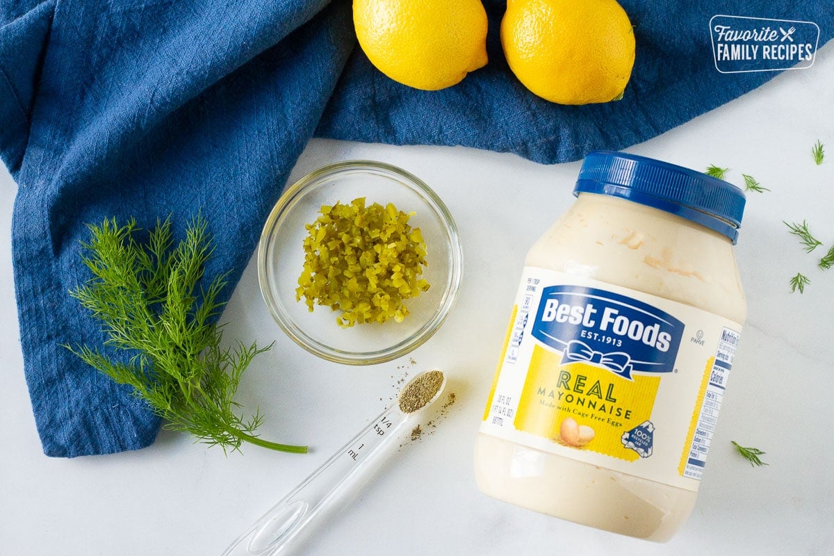 Ingredients to make Homemade Tartar Sauce including mayonnaise, dill, dill pickles, pepper and lemons.