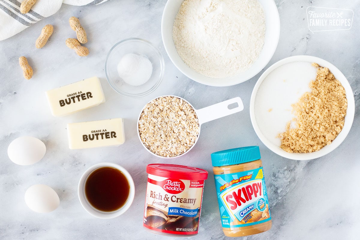 Ingredients for Peanut Butter Bars including butter, eggs, vanilla, milk chocolate frosting, peanut butter, sugars, flour, oatmeal, salt and baking soda.