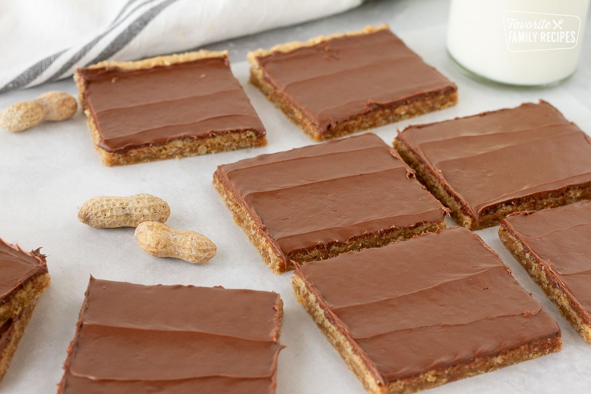 Lots of Peanut Butter Bars frosted and cut into squares. Milk on the side.