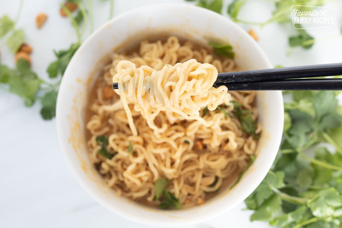 A close up of noodles twirled around chopsticks