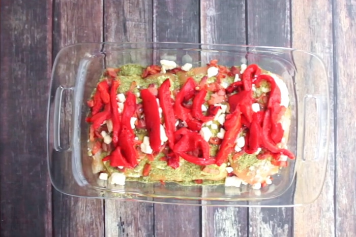 Red peppers, bacon, dried pesto, feta, and olive oil spread over chicken breasts for Pesto Chicken with Roasted Red Pepper.