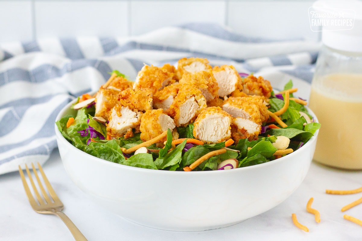 Applebee's Oriental Chicken Salad in a bowl with homemade dressing on the side.