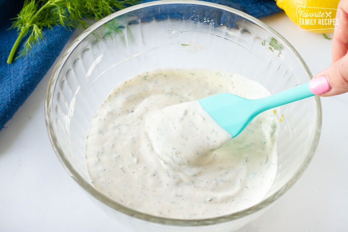 Spatula scooping Homemade Tartar Sauce in a mixing bowl.