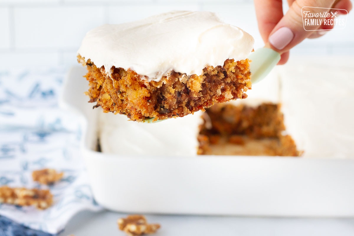 Spatula holding a slice of Classic Carrot Cake with cream cheese frosting.