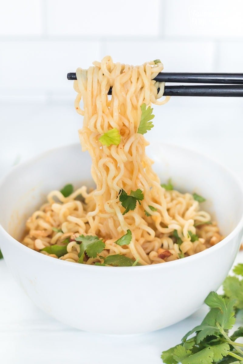 Chopsticks pulling up peanut butter ramen noodles from a bowl