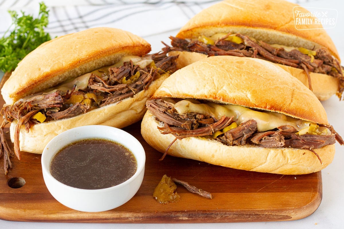 Three Italian Beef Sandwiches with au jus sauce for dipping.