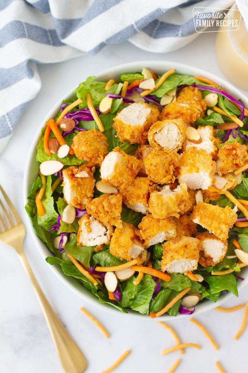 Applebee's Oriental Chicken Salad with lettuce, cut up fried chicken, red cabbage, carrots, almonds and noodles.