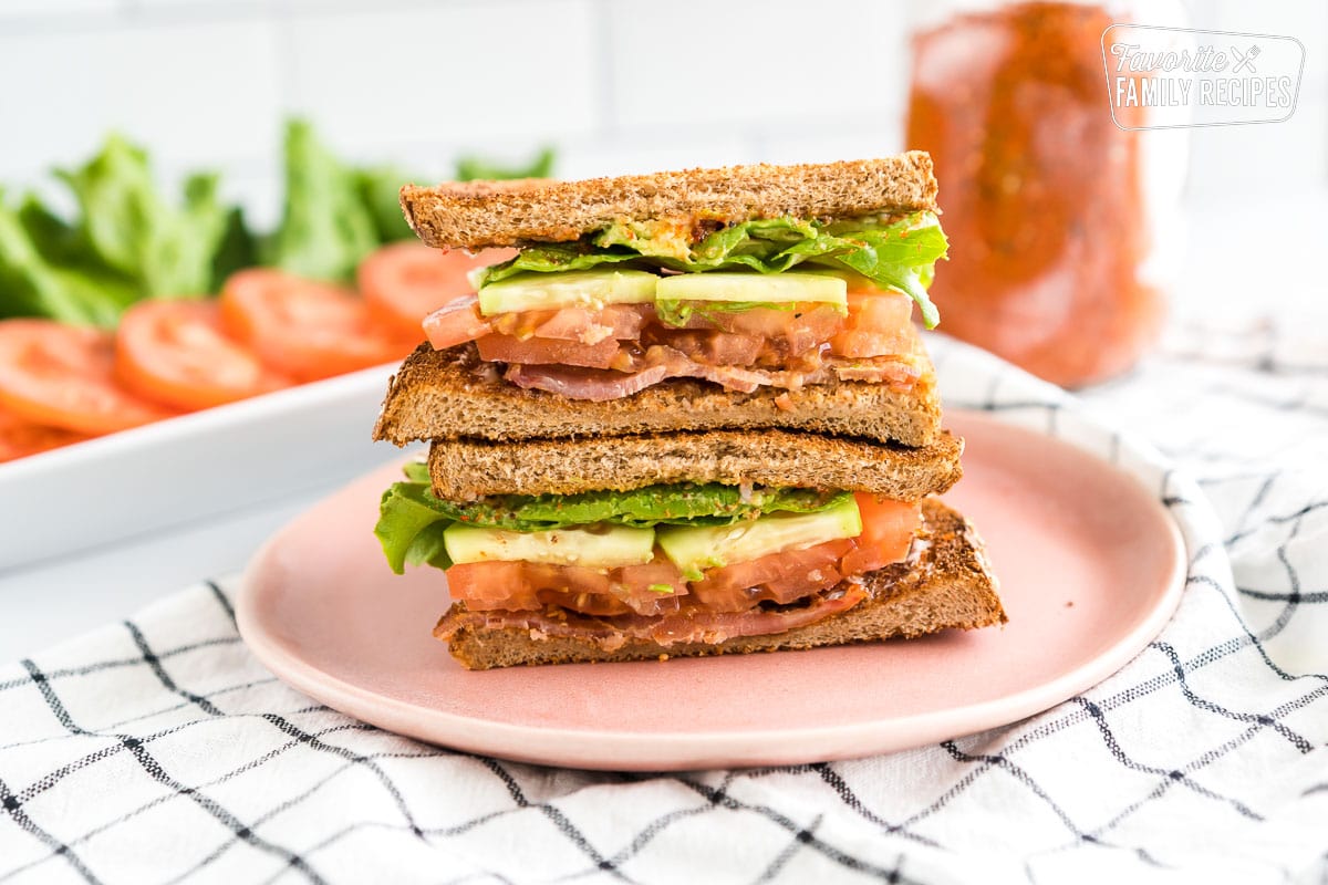 This Ultimate BLT Sandwich is fresh and crisp, with avocado and cucumbers added to traditional bacon, lettuce and tomato. A perfect sandwich! Ultimate BLT sandwich sliced in half and stacked on top of each other.