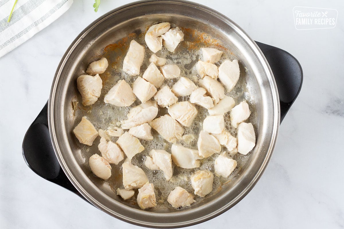 Chicken cooking in a pot with oil for Jambalaya Pasta.