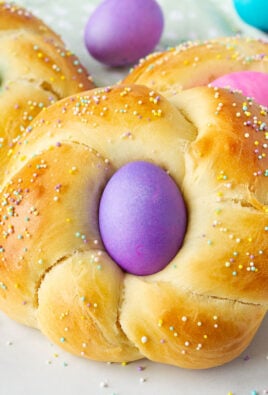 Close up view of Easter bread with a purple colored egg and sprinkles.