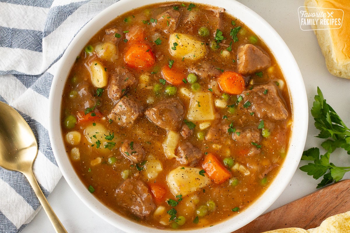 Bowl of Hearty Beef Stew garnished with parsley. Spoon on the side.