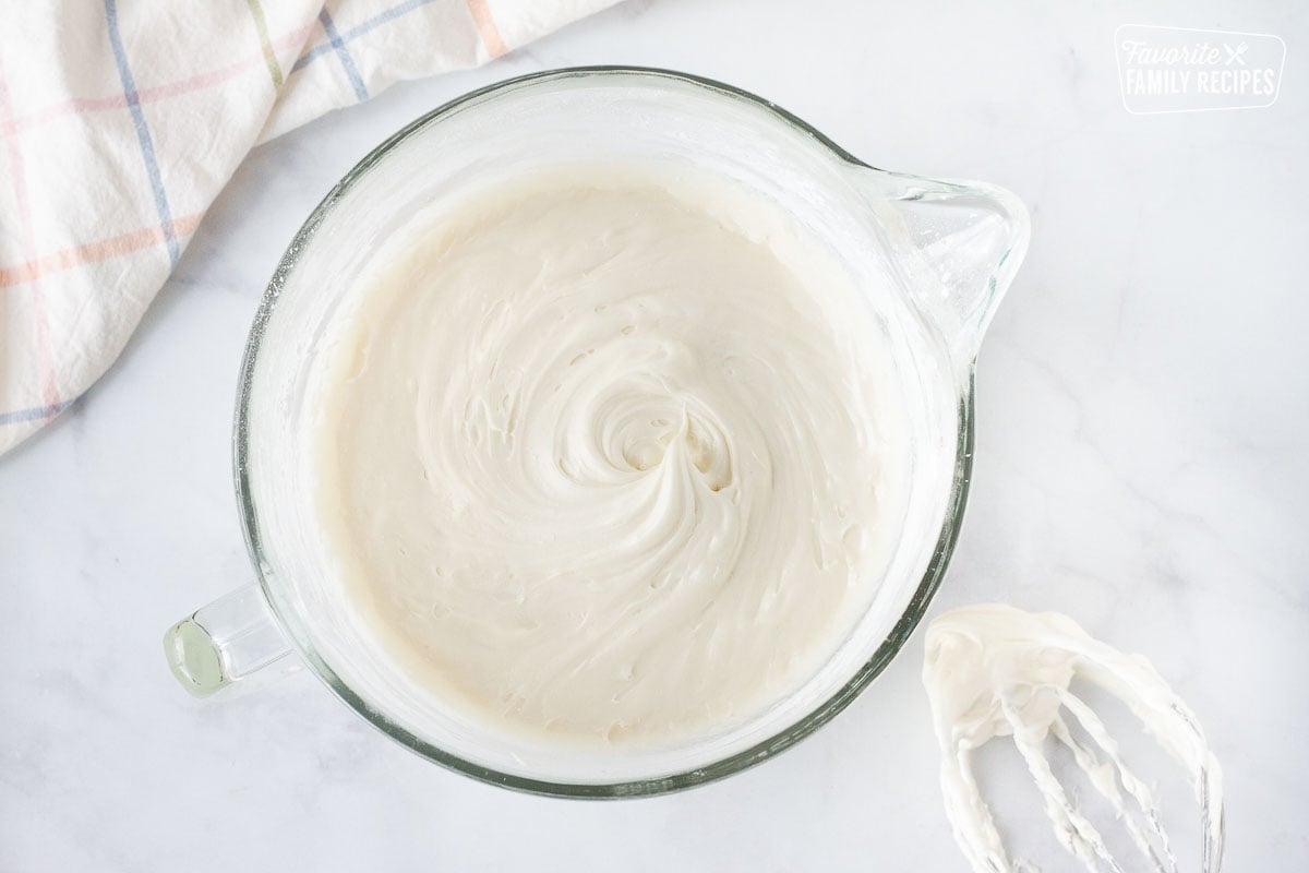 Mixing bowl with cream cheese frosting for Carrot Bundt Cake.