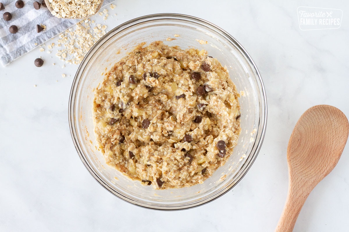 Bowl with cookie dough for Healthy Oatmeal Cookies. Wooden spoon on the side.