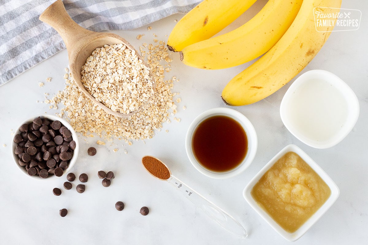 Ingredients to make Healthy Oatmeal Cookies including bananas, oats, chocolate chips, applesauce, milk, vanilla and cinnamon.