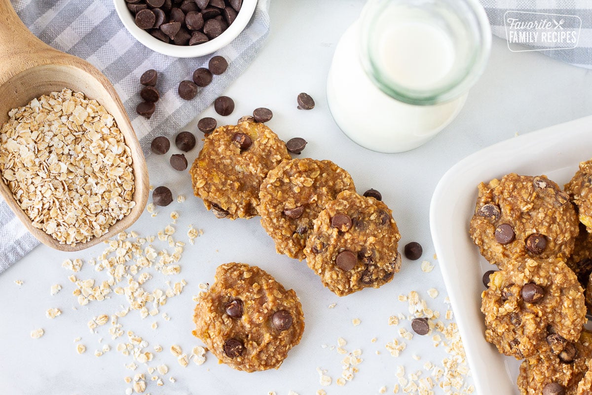 Healthy Oatmeal Cookies with milk. Oats and Chocolate chips on the side.