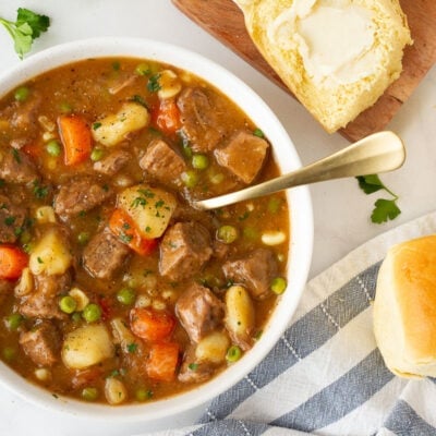 Bowl of Hearty Beef Stew with dinner rolls.