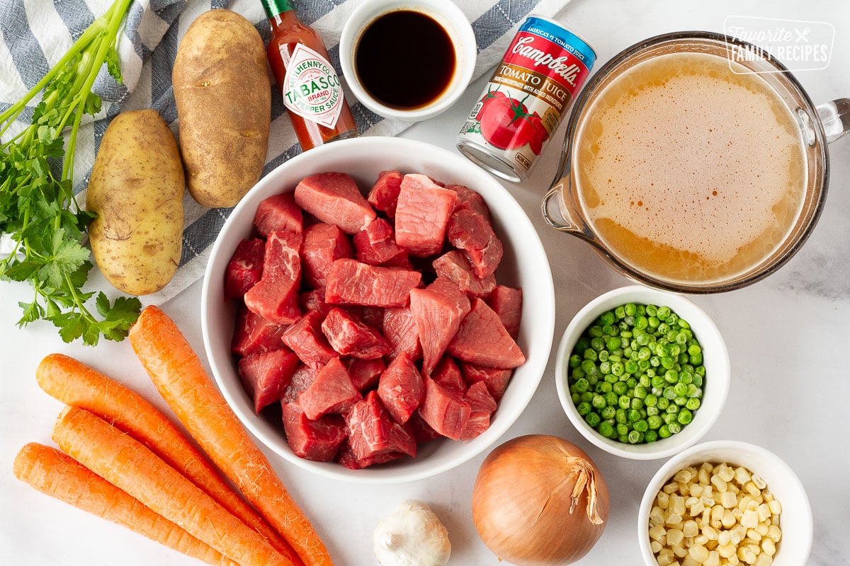Ingredients for Hearty Beef Stew including beef, potatoes, carrots, peas, corn, onion, garlic, beef broth, tabasco, Worcestershire sauce and tomato juice.
