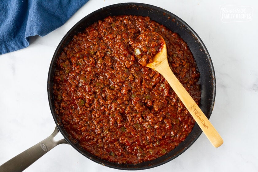 Skillet of Homemade Sloppy Joe filling with a wooden spoon.