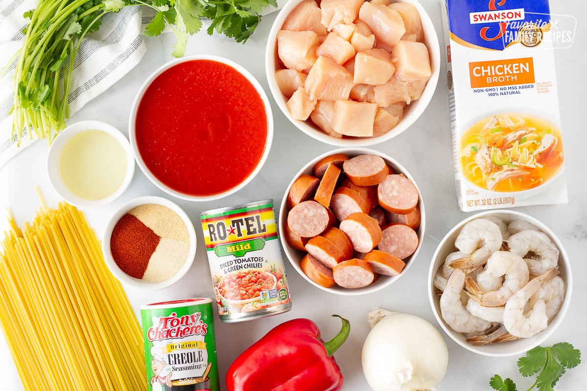 Ingredients for Jambalaya Pasta including chicken, sausage, shrimp, chicken broth, tomato sauce, Rotel tomatoes, onion, red bell pepper, cilantro, pasta, creole seasoning, spices and oil.