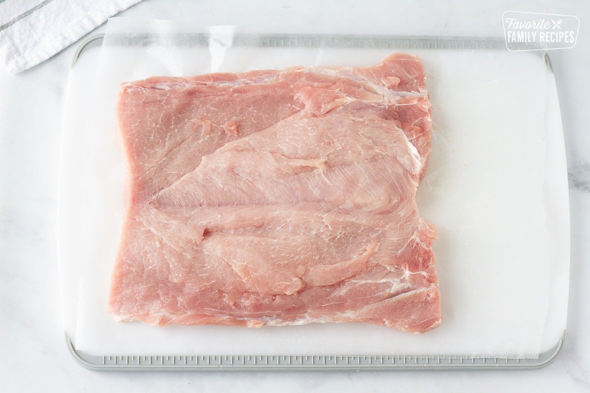 Cutting board with cut Pork Loin laying flat for Stuffed Pork Loin.