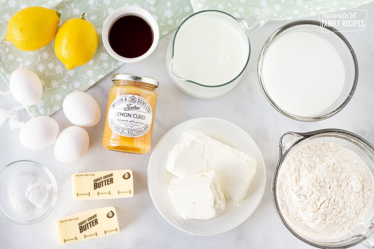 Ingredients to make Lemon Cupcakes including lemon curd, eggs, lemons, vanilla, buttermilk, sugar, flour, cream cheese, butter, salt and baking soda.