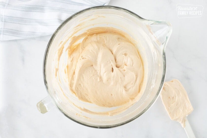 Mixing bowl with peanut butter filing layer for Costco Peanut Butter Chocolate Cream Pie. Spatula on the side.