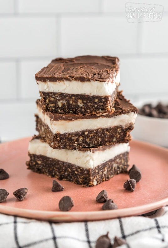 Three Nanaimo Bars stacked on a plate