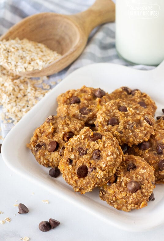 Plate of Healthy Oatmeal Cookies with a glass of milk and oats on the side.