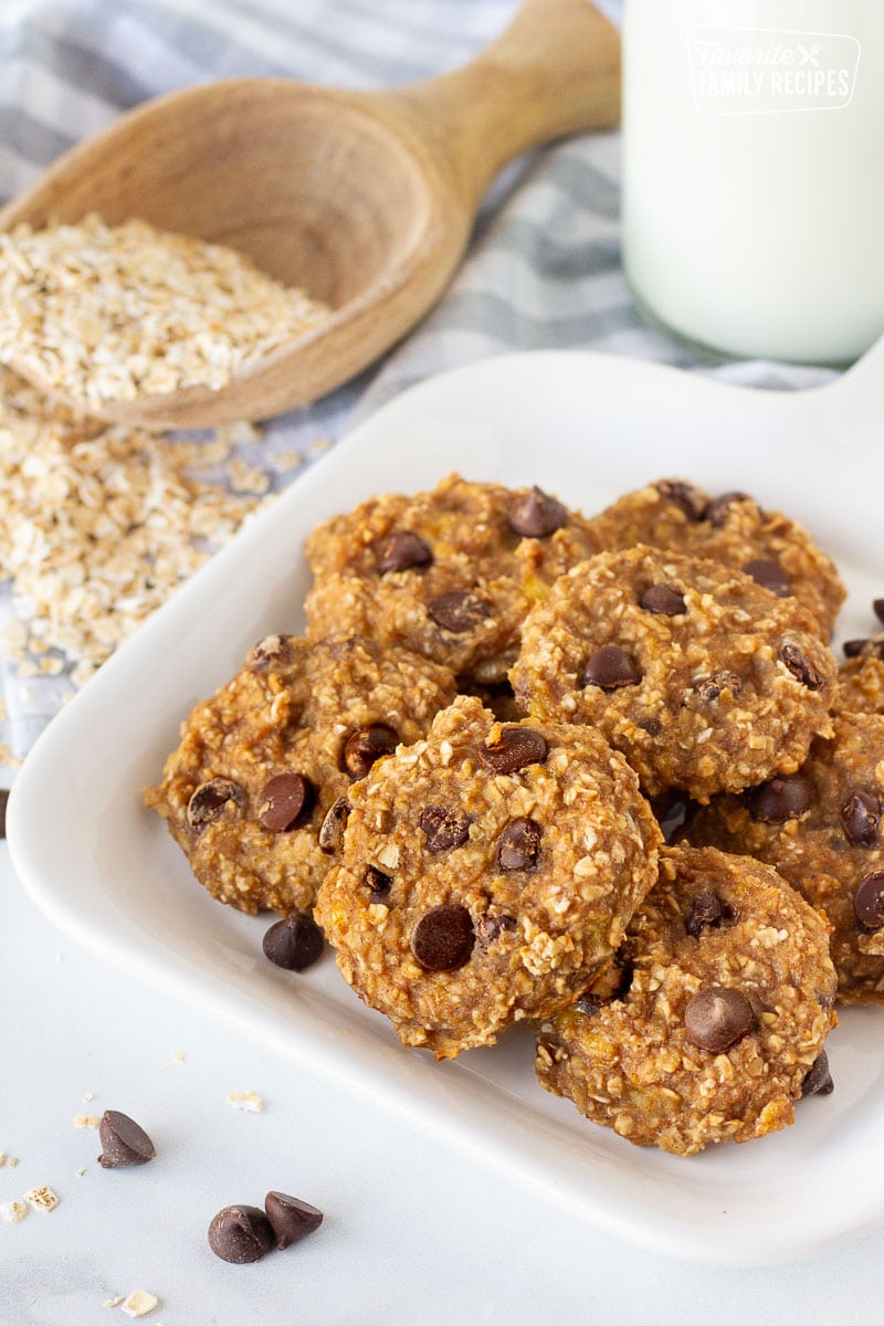 Plate of Healthy Oatmeal Cookies with a glass of milk and oats on the side.