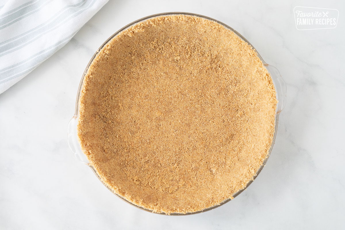 Pressed pie crust in a glass pie dish for Costco Peanut Butter Chocolate Cream Pie.