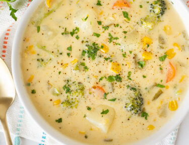 Close up bowl of Creamy Vegetable Soup with carrots, broccoli, corn, celery and potatoes.