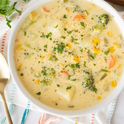 Close up bowl of Creamy Vegetable Soup with carrots, broccoli, corn, celery and potatoes.