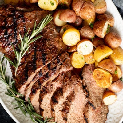 Tri Tip Roast on a serving platter with potatoes.
