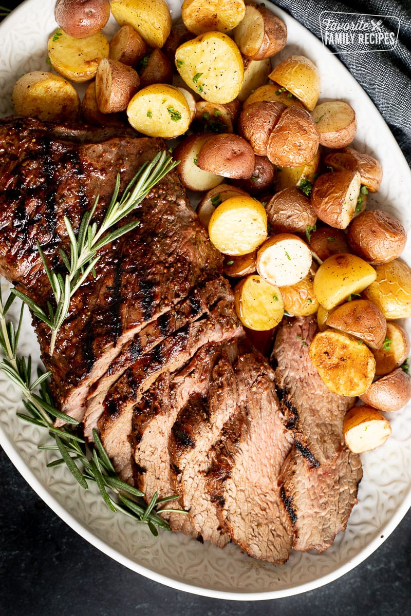 Tri Tip Roast on a serving platter with potatoes.