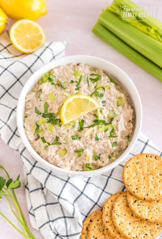 Tuna salad in a white bowl with celery and crackers.