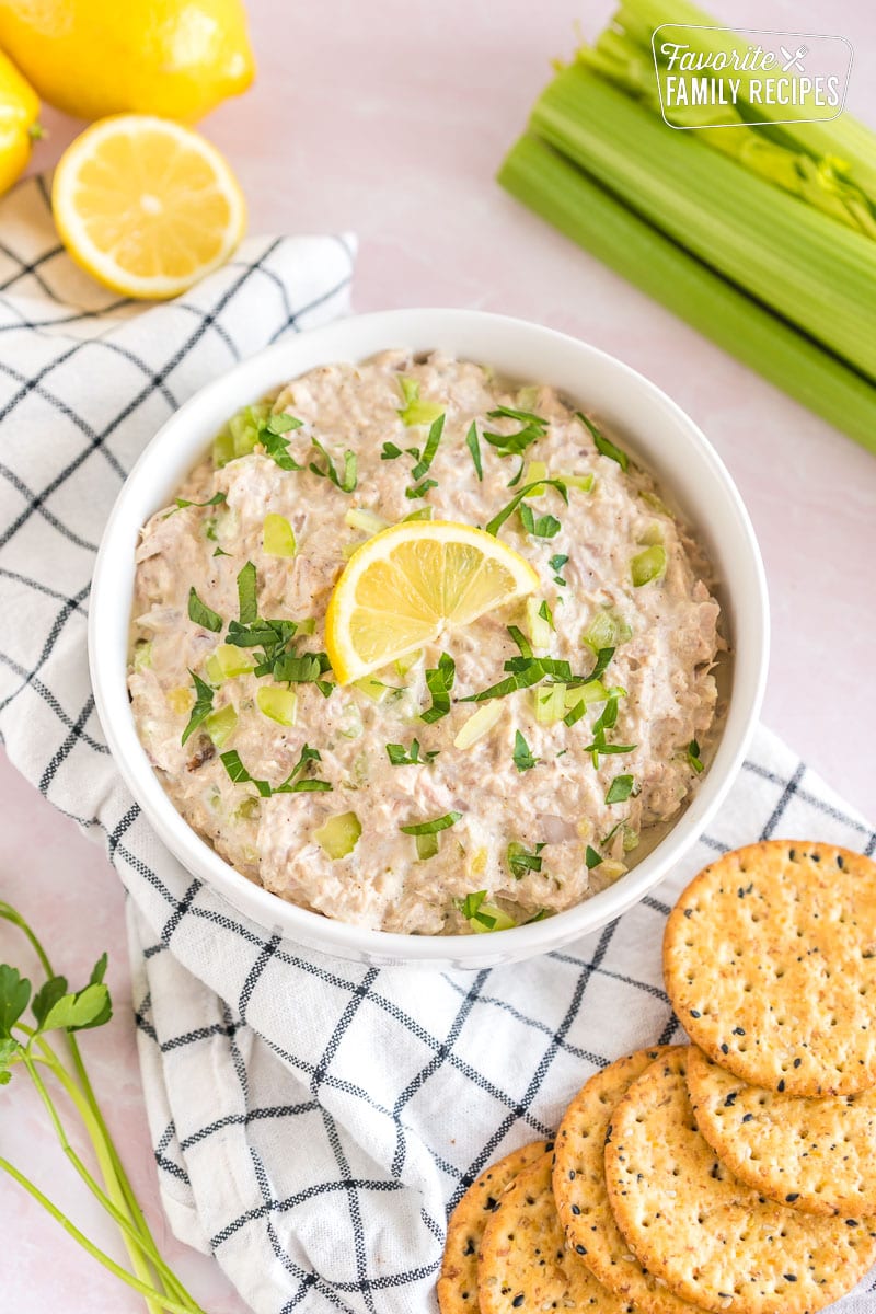 a bowl of tuna salad topped with a lemon slice