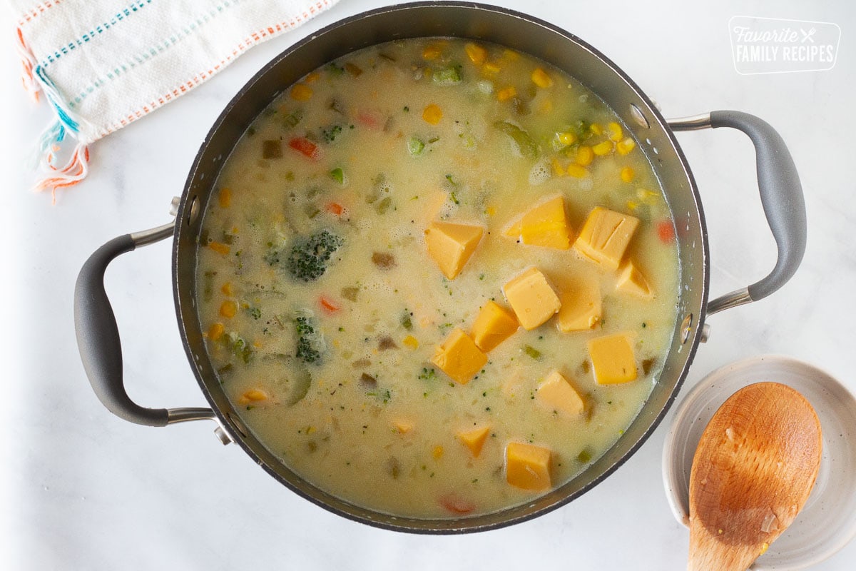 Velveeta added to pot of Creamy Vegetable Soup with carrots, corn, broccoli and celery.