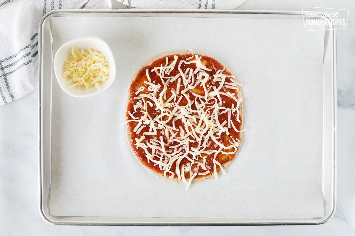 Baking sheet with mozzarella cheese on top of the flatbread for Healthy Pizza.