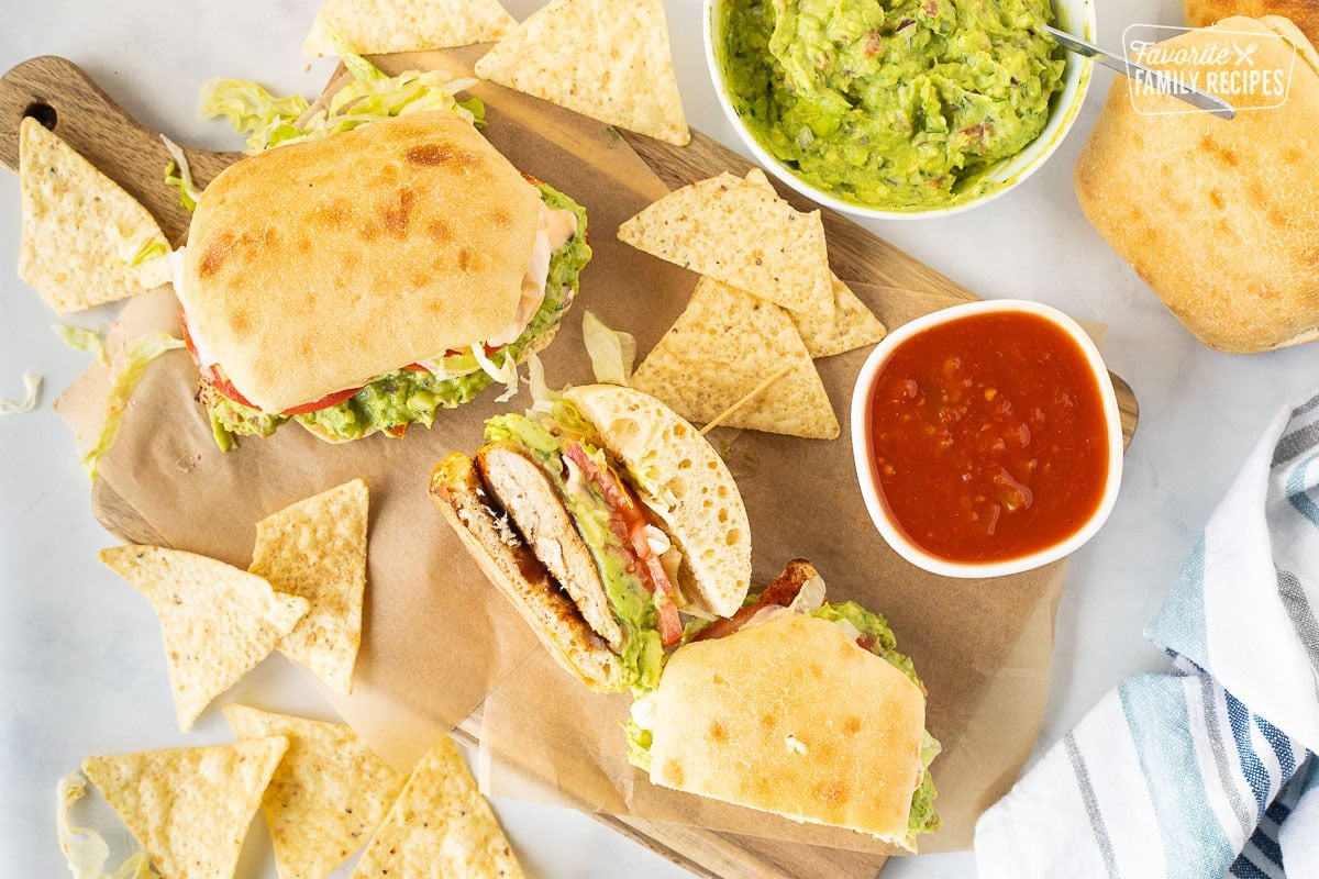 These Guacamole Chicken Torta Sandwiches are my kind of Mexican food! Seasoned grilled chicken on Torta bread loaded with guacamole, lettuce, tomatoes, and chipotle ranch dressing. Chicken Torta Sandwiches with guacamole, salsa and tortilla chips.