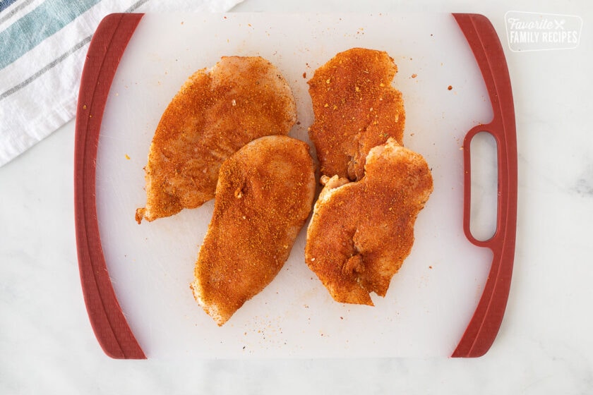 Four pieces of thin chicken breast rubbed with seasonings for Chicken Tortas.