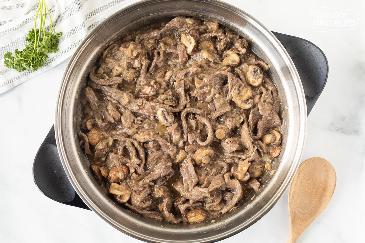 Skillet with cooked beef, mushrooms and onions for Easy Beef Stroganoff.