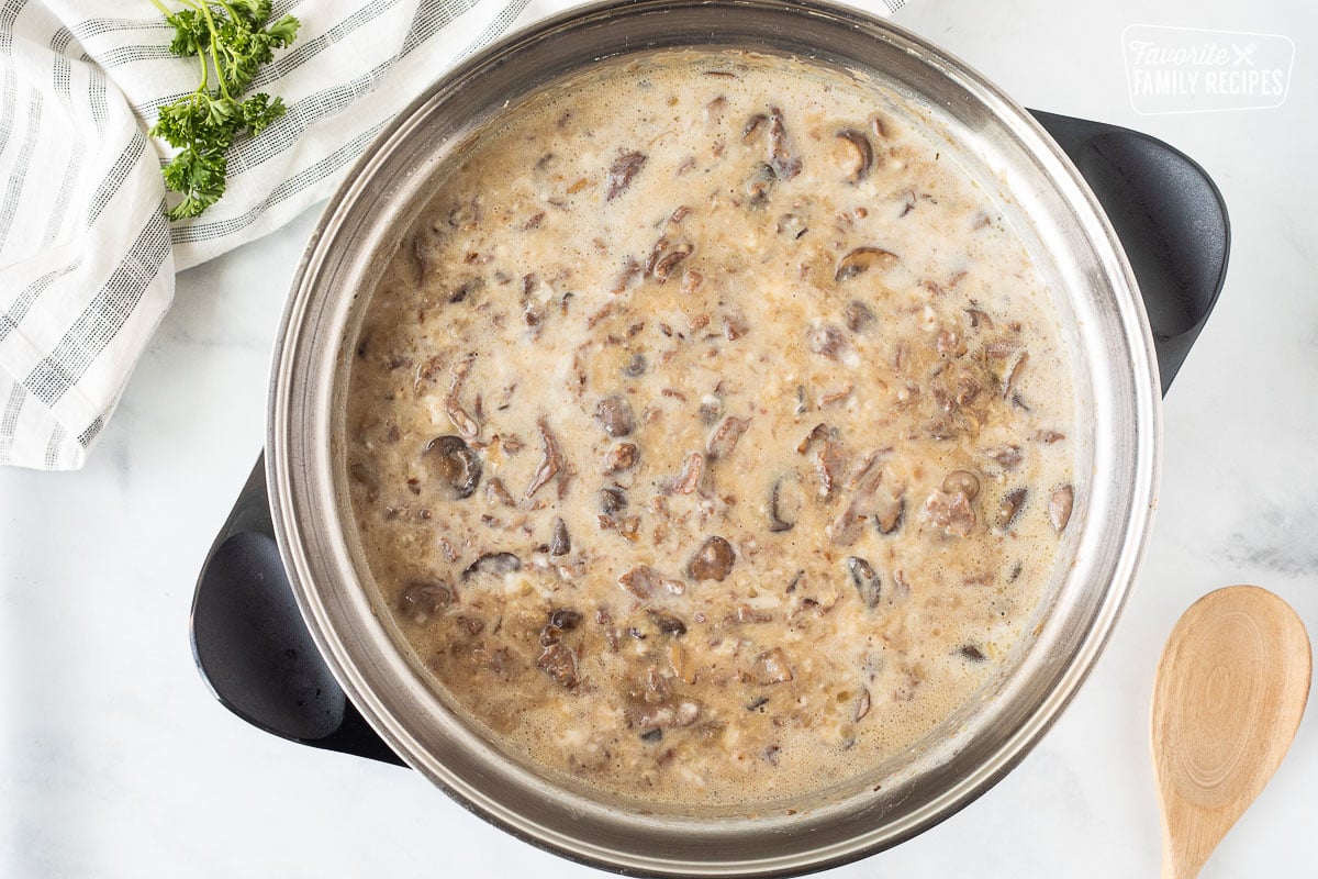 Skillet with cream of mushroom and milk added to Easy Beef Stroganoff.