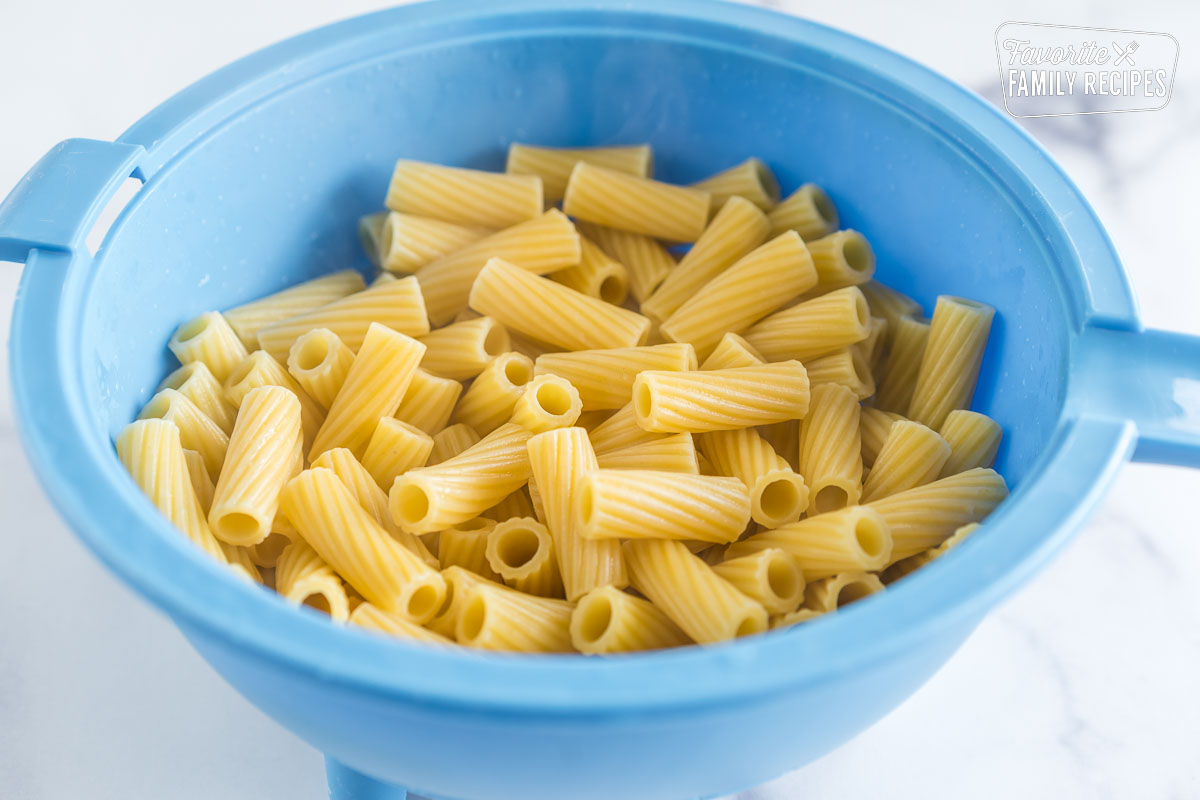 pasta draining in a blue colander