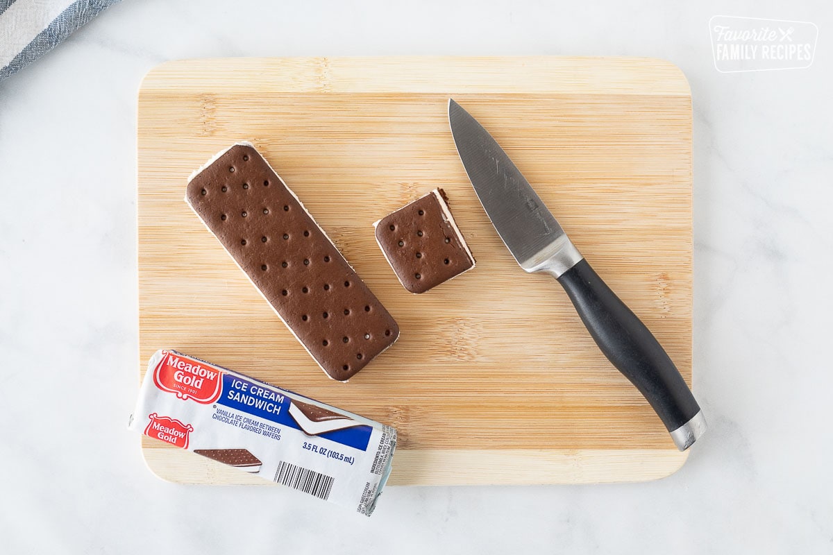 Cutting board with a knife and a cut Ice Cream Sandwich for Cake.