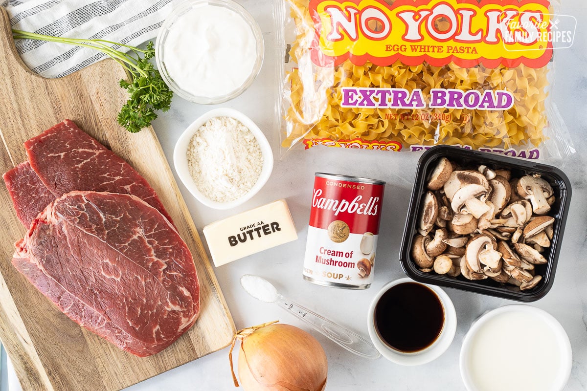 Ingredients for Easy Beef Stroganoff including noodles, beef rounds, onions, flour, sour cream, milk, worcestershire sauce, mushrooms, butter, salt and cream of mushroom soup.