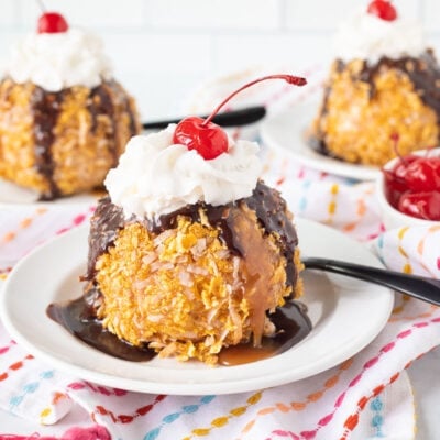 Three plates of Fried Ice Cream with caramel sauce, chocolate sauce, whipped cream and a cherry on top.