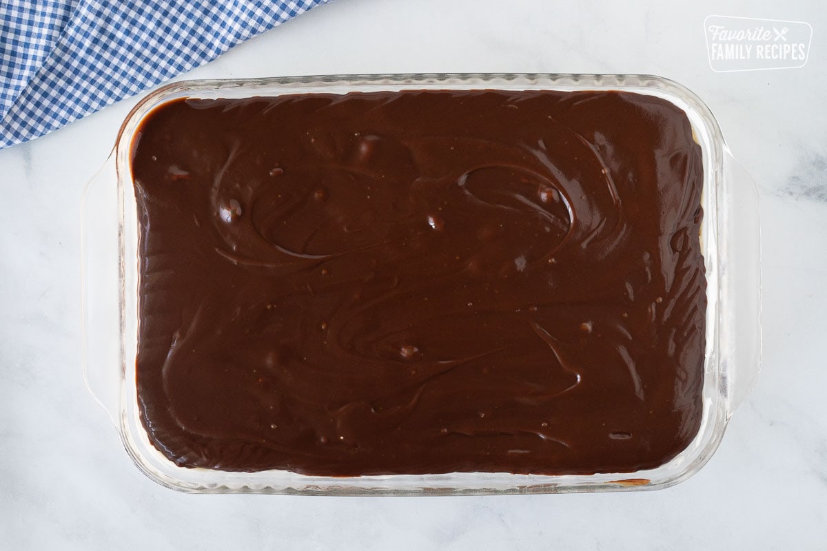 Glass rectangle dish with a fudge layer for Banana Split Dessert.