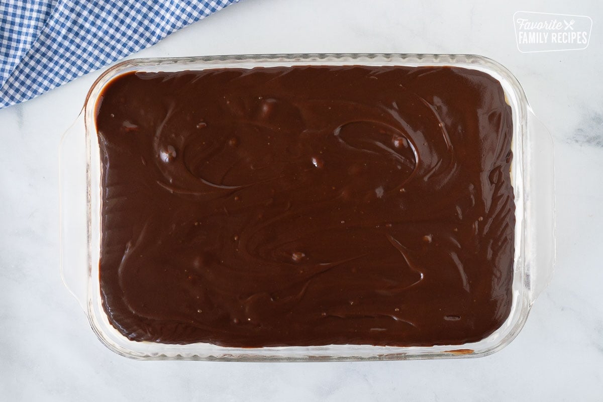 Glass rectangle dish with a fudge layer for Banana Split Dessert.