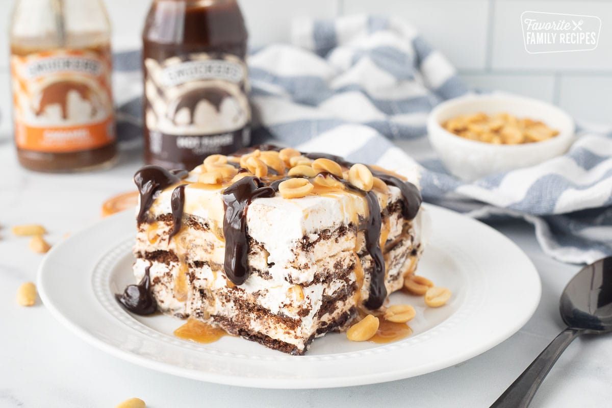 Ice Cream Sandwich Cake on a plate with hot fudge, caramel and peanuts.