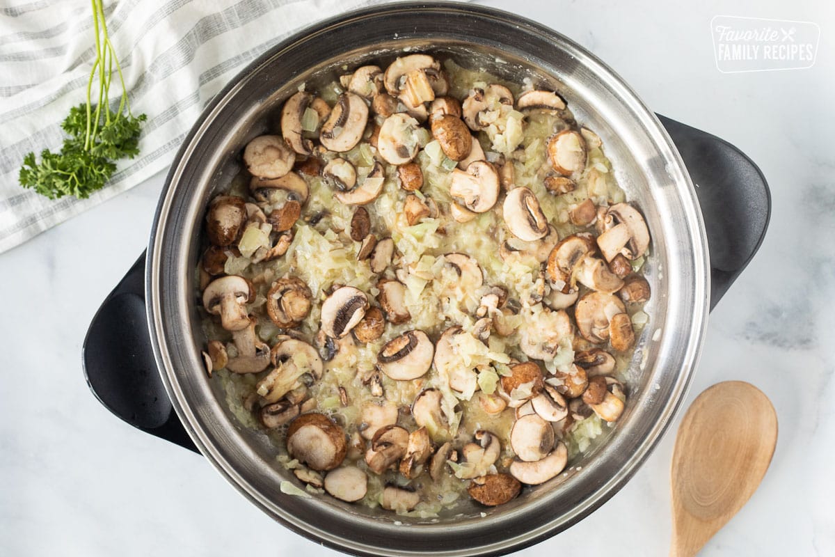 Skillet with mushrooms, butter and onions for Easy Beef Stroganoff.